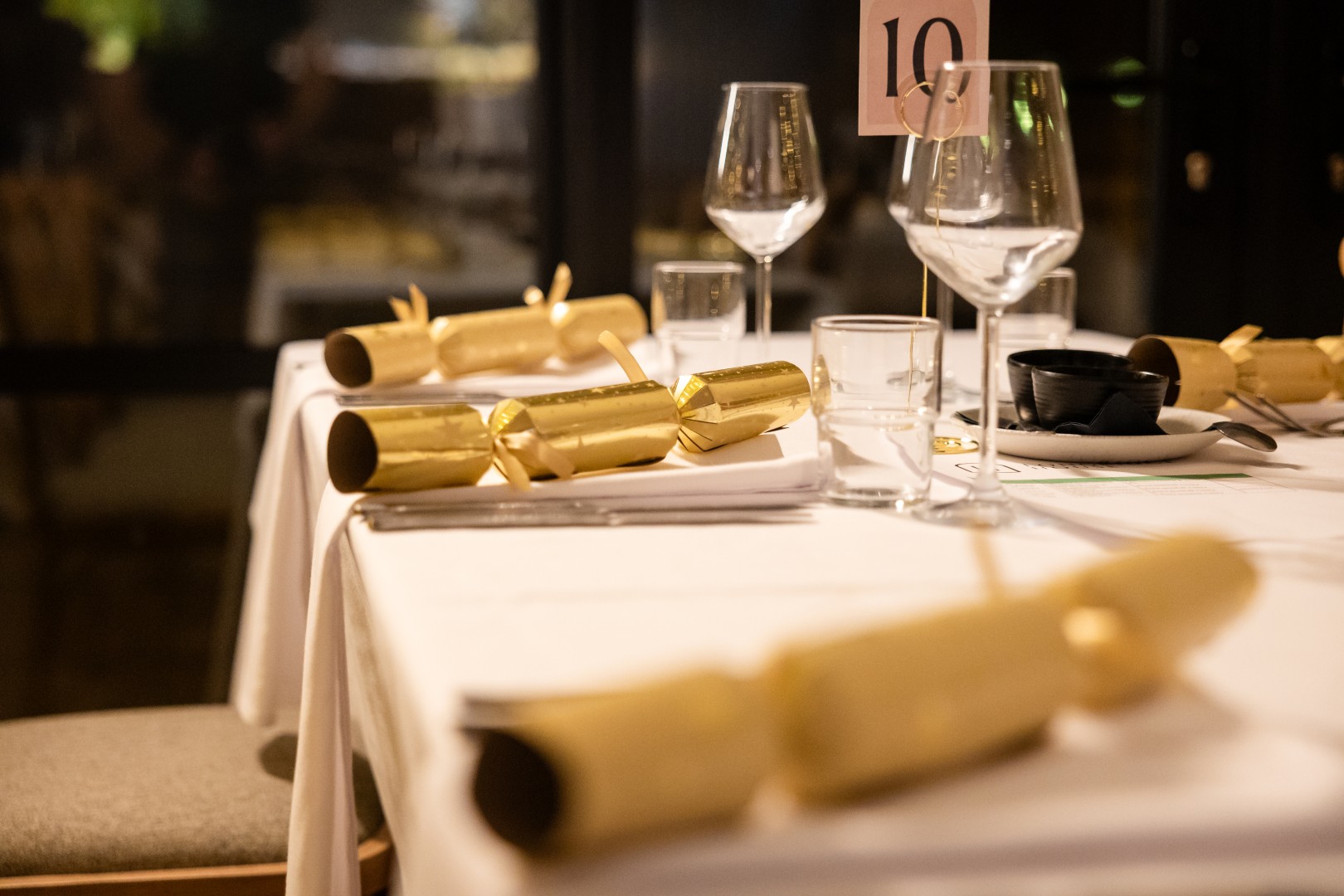 Christmas table setting at Longridge House with gold crackers and wine glasses